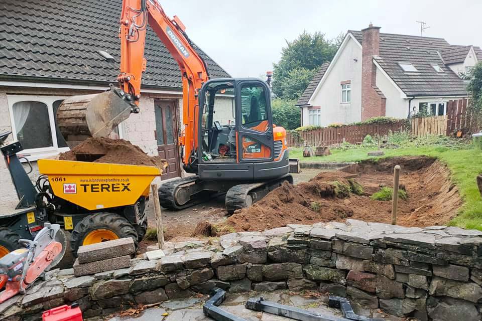 Small jcb doing GroundWorks in domestic back garden